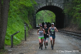 Megan DiGregorio of Baltimore running top master Pete LoBianco #204 just south of the Howard Tunnel, in the pouring rain.