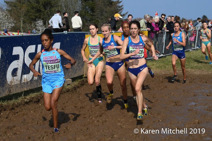Stephanie Bruce of USA, a veteran of two World XC heads through the mud, just ahead of three USA teammates. Dolshi Tesfu of Eritrea, placed 38th, and Emily Brichacek of Australia, placed 35th.