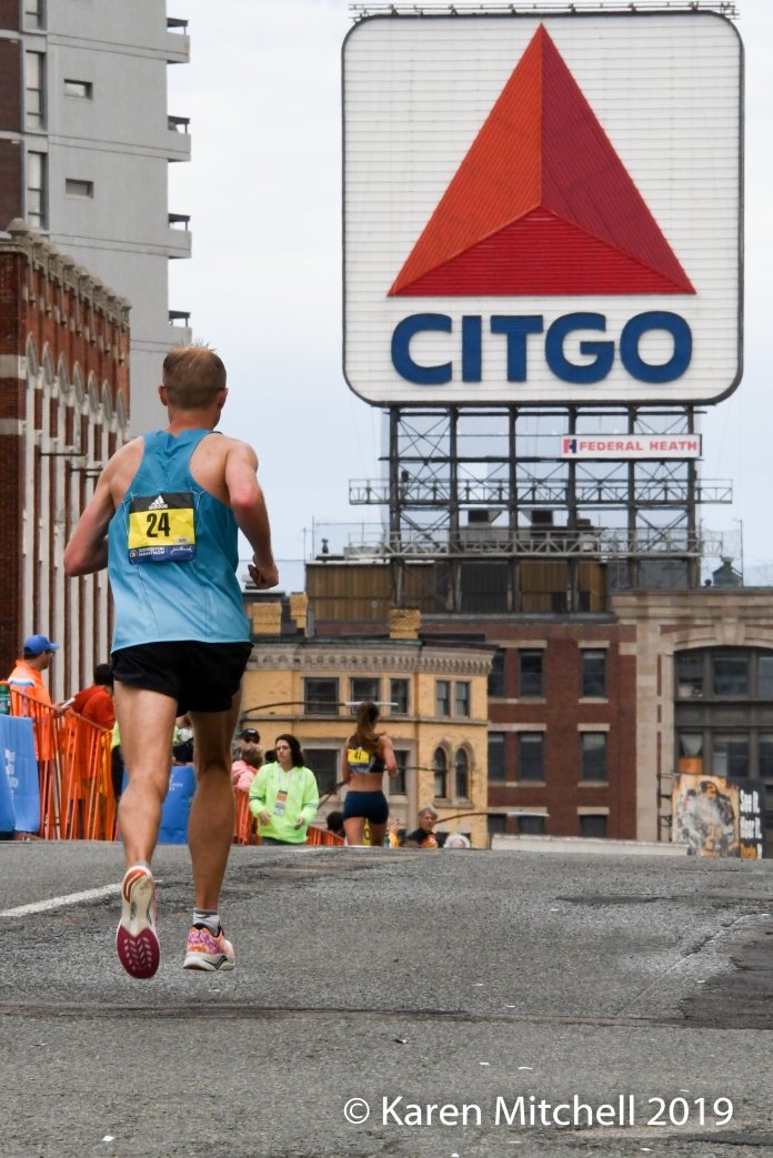 Jared Ward #24 in the final 2K of the Boston Marathon. The iconic Citgo sign and Kenmore Square loom ahead. Ward had a great day with a 2:09:25 and 8th overall.