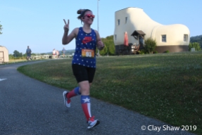 Lacy Deller in July 4 patriotic gear gives me the peace sign while rounding the Shoe House.