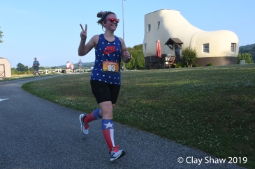 Lacy Deller in July 4 patriotic gear gives me the peace sign while rounding the Shoe House.