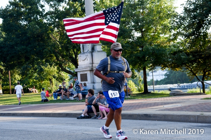 Miguel Encinas of Bridgeport, Ohio runs the Debbie Green Memorial 5K with the USA flag.